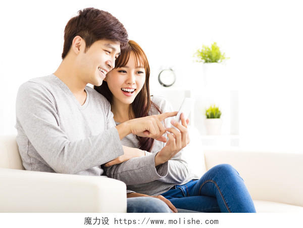 幸福夫妻在客厅里看智能手机